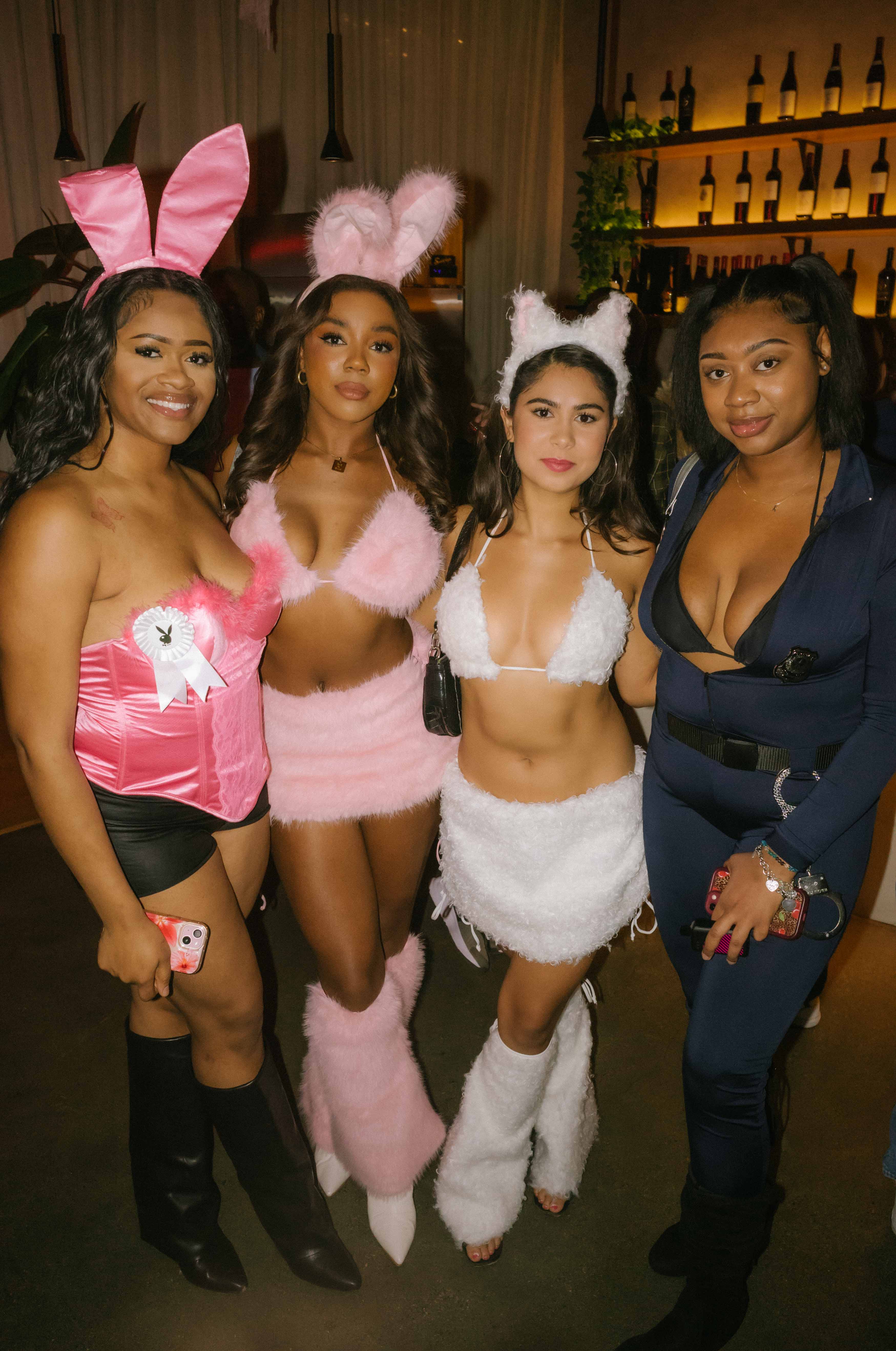 Four guests in bunny, cat and police costumes posing together at The Cookout LA Halloween party